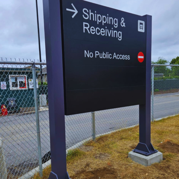 Pylon sign near hospital grounds displaying directional information for Shipping and Receiving areas.